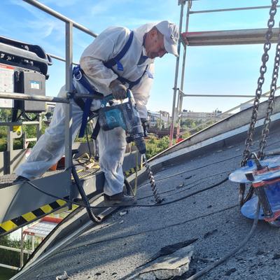 Mitarbeiter mit Absturzsicherung bei Arbeiten auf dem Hallendach