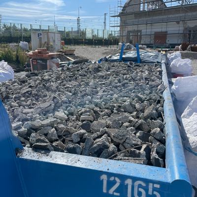Abrollcontainer mit sortiertem Betonbruch auf der Baustelle