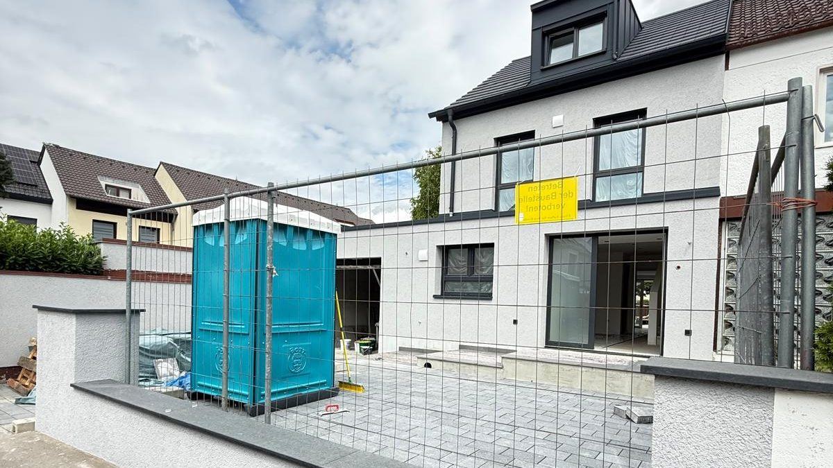 Saniertes Wohngebäude mit Baustelleneinrichtung im Außenbereich