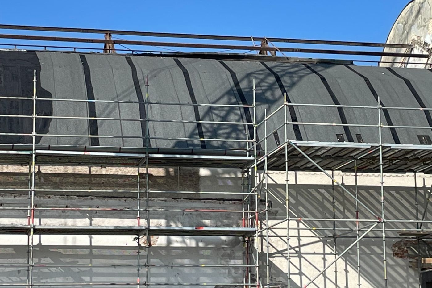 Eingerüstete Halle mit freigelegter Dachkonstruktion während der Sanierung